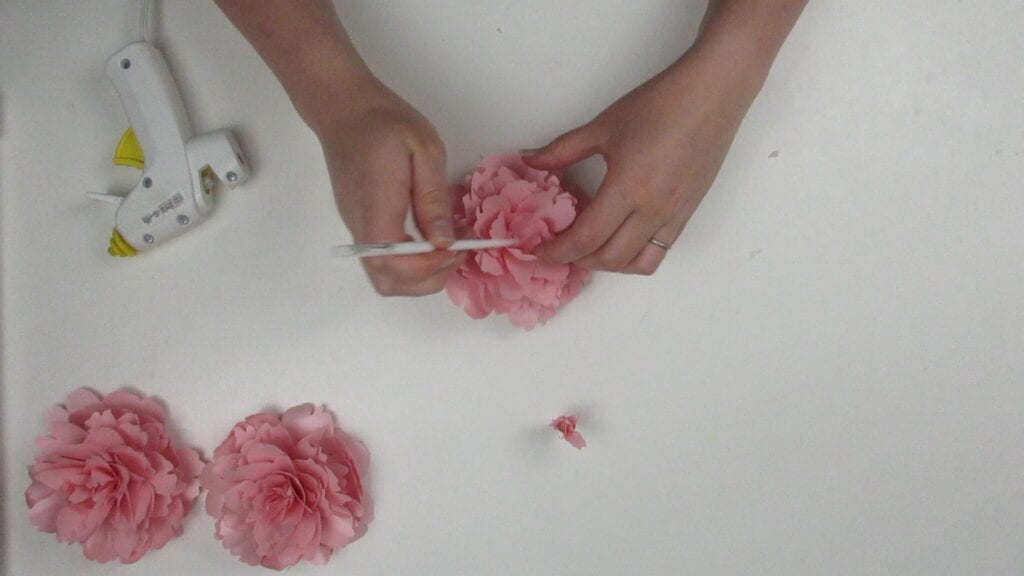 using a paintbrush to glue the peony together