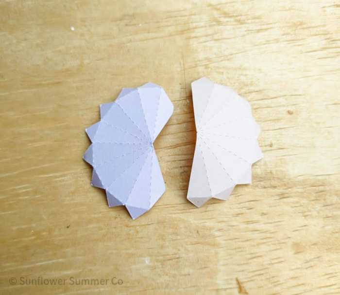 The first two pieces of the paper sphere folded